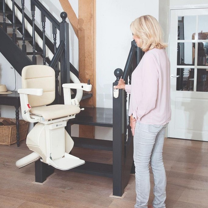 Lady Standing Next to a Curved Stairlift